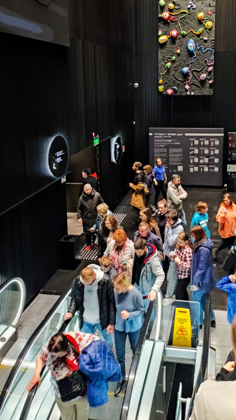 Поток людей у эскалатора на одном из нижних уровней павильона «Атом»