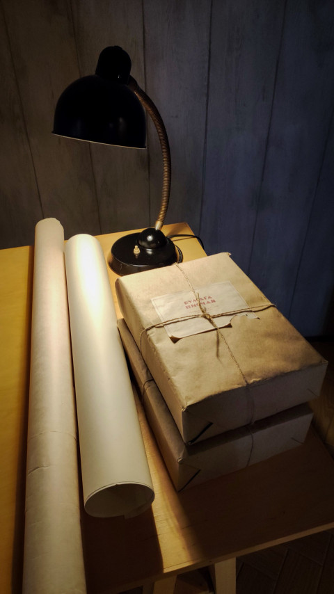 Рулоны бумаги и архивные пакеты под настольной лампой в павильоне «Атом»