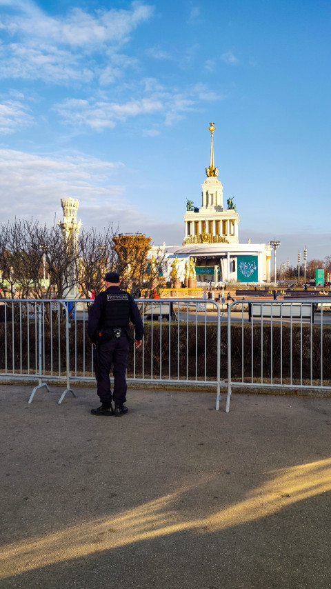 Сотрудник полиции перед павильоном №1 и фонтаном «Дружба народов» на ВДНХ