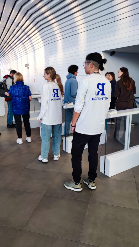 Волонтёры и посетители у турникетов павильона «Атом» на ВДНХ