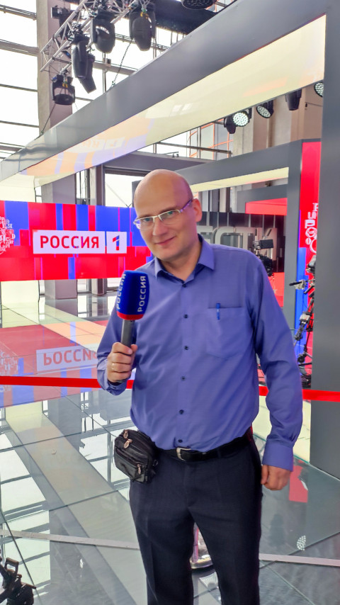 Мужчина с микрофоном «Россия» на стеклянной платформе экспозиции