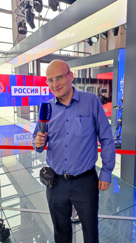 Участник выставки у логотипа «Россия 1» в павильоне №75