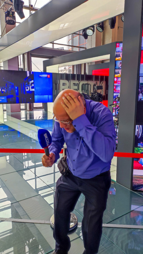 Посетитель с микрофоном «Россия» в зоне студийного стенда телеканала