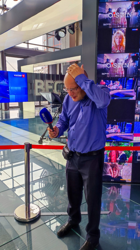 Мужчина с микрофоном в зоне видеостены выставки