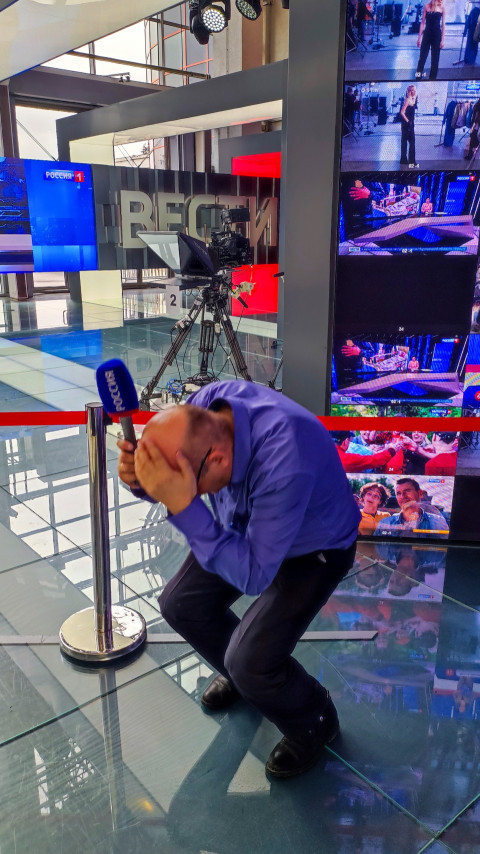 Посетитель, присевший с микрофоном в зоне «Россия 1»