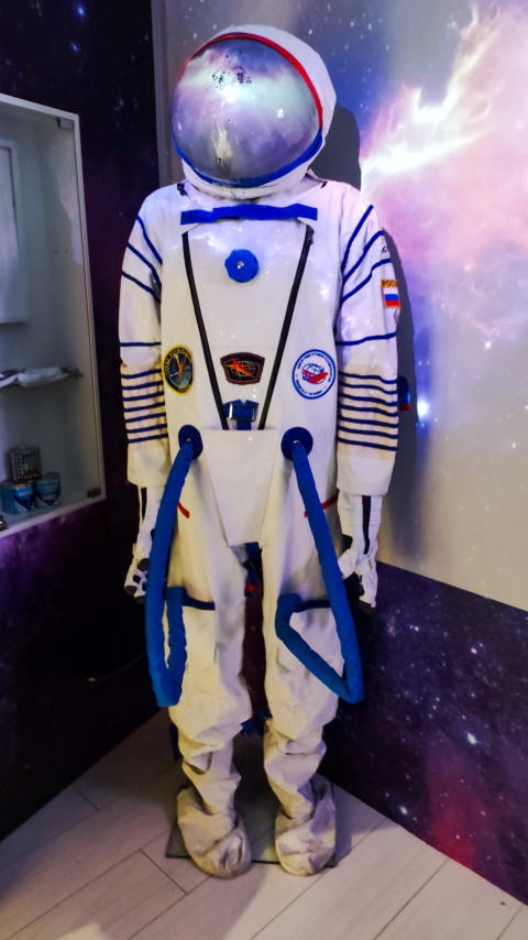 Космический скафандр на манекене в экспозиции с панорамной проекцией галактики