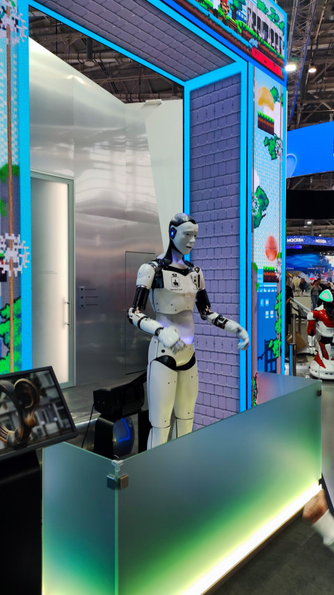 Гуманоидный робот на стенде с цифровыми панелями на выставке «Россия»