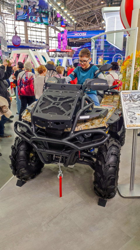 Посетитель на квадроцикле на выставочном стенде