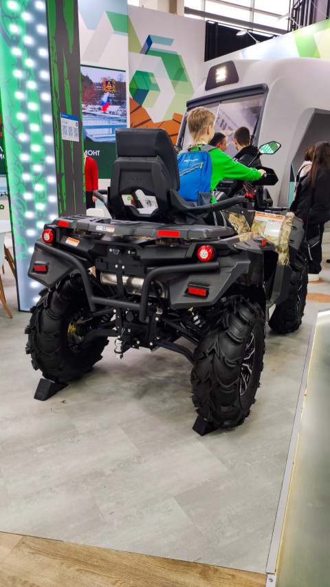 Посетители исследуют квадроцикл на выставочном стенде