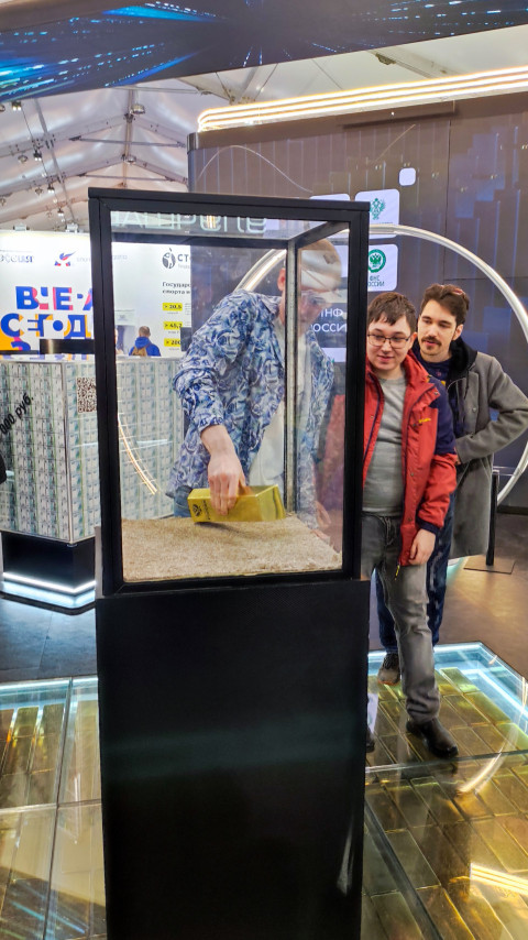 Молодые посетители взаимодействуют с макетом слитка на интерактивной площадке Минфина