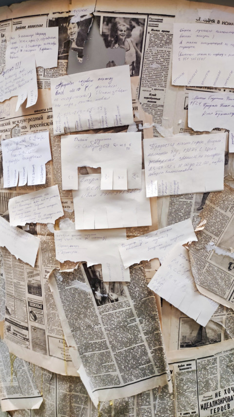 Стена с заметками и газетными вырезками, имитирующая объявления советского периода