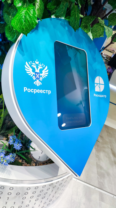 Интерактивная стойка Росреестра среди декоративной зелени