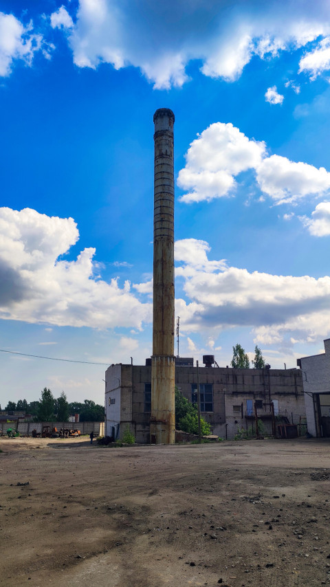 Металлическая дымовая труба на территории промышленного здания