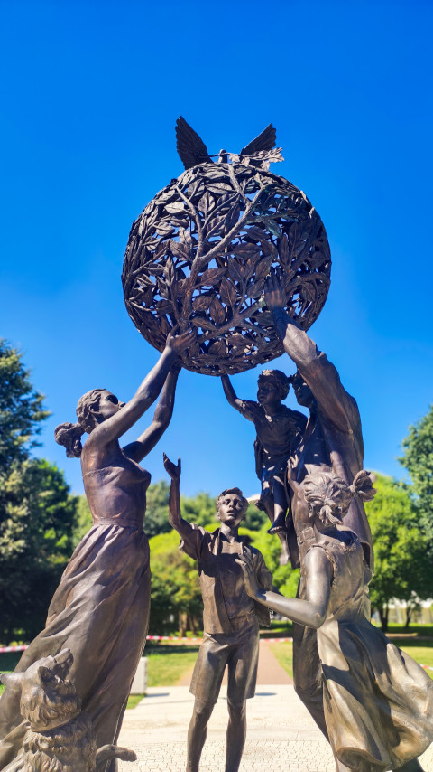Бронзовые фигуры семьи поднимают земной шар из ветвей в композиции «Семья — залог мира»