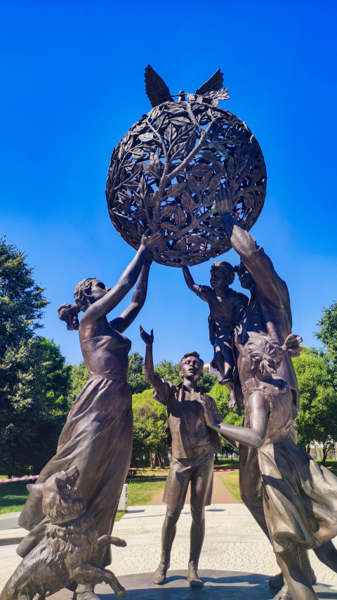 Композиция «Семья — залог мира» с земным шаром и голубями на фоне деревьев парка 300-летия Санкт-Петербурга