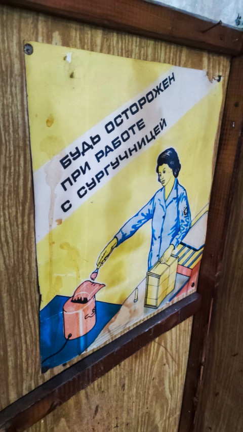 Крупный план плаката «Будь осторожен при работе с сургучницей» с крепежом