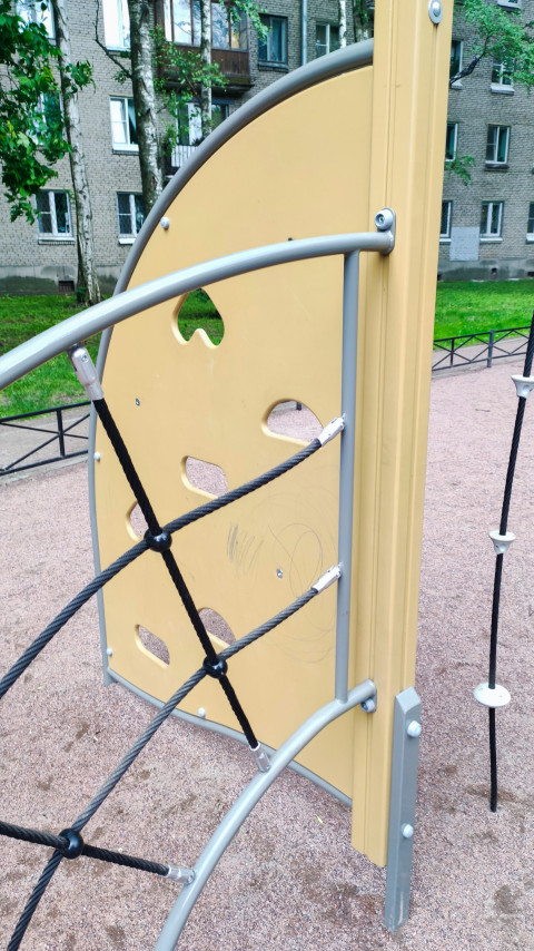 Элемент лазалки на детской площадке с верёвочной сеткой и жёлтой панелью