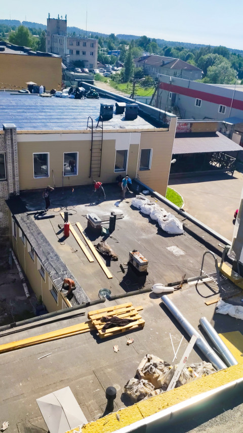 Монтаж рулонной гидроизоляции на плоской крыше с рабочей зоной и материалами