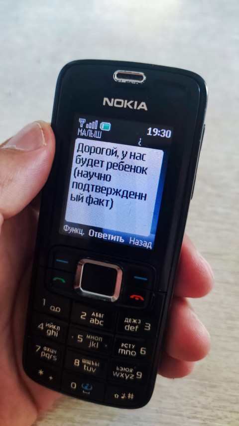 Телефон Nokia с SMS о будущем ребенке на экране при времени 19:30