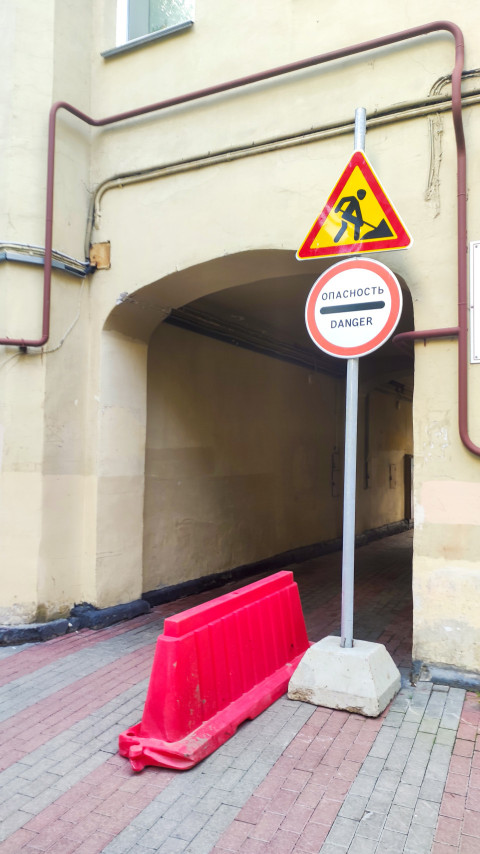 Дорожные знаки «Дорожные работы» и «Опасность» у арочного прохода с пластиковым барьером