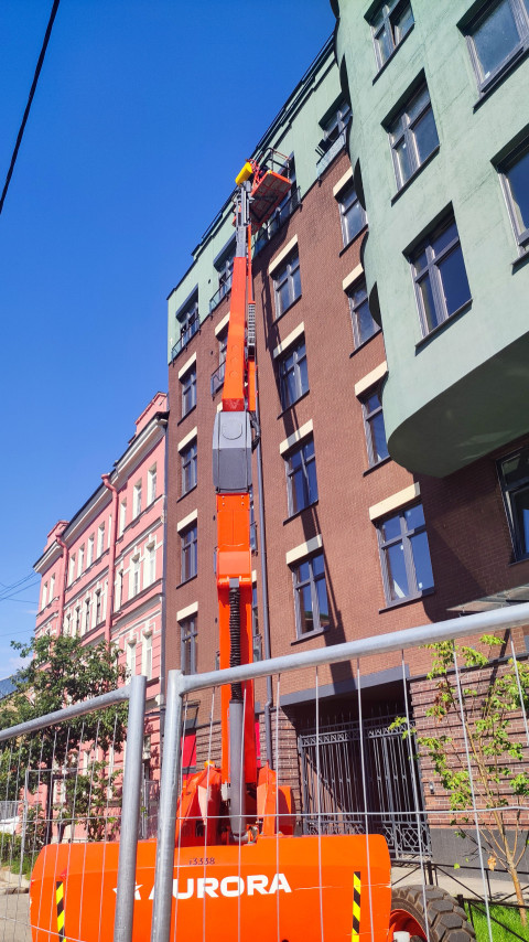 Автовышка у фасада здания для обслуживания остекления и наружных работ на высоте