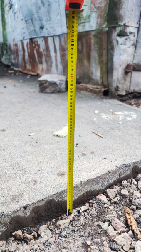 Измерение уровня асфальта рулеткой у кромки покрытия на участке ремонта