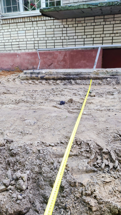 Измерение рулеткой расстояния от песчаного основания до ступеней входной группы