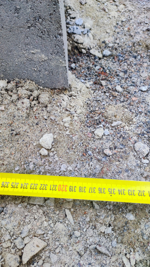 Замер рулеткой у поворота бордюра на щебёночном основании с читаемой шкалой