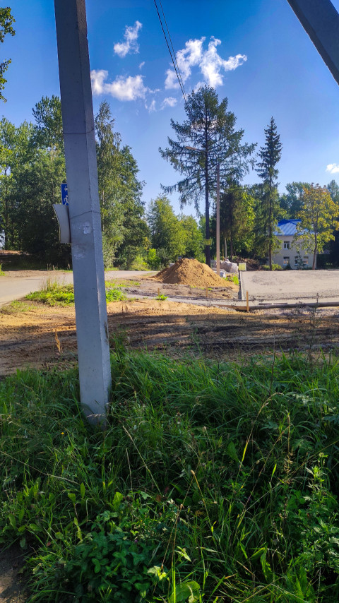 Опора уличного освещения у стройплощадки в парке с песчаными насыпями