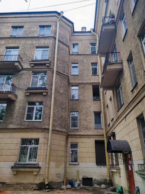 Внутренний двор-колодец жилого дома с водостоками и балконами