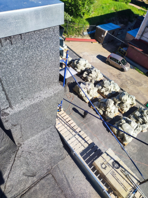 Ремонтный участок плоской кровли с парапетом, ограждением и строительными материалами