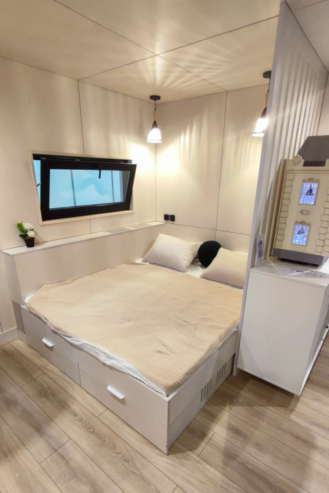 Спальня с кроватью и окном в модульном доме Aira Homes