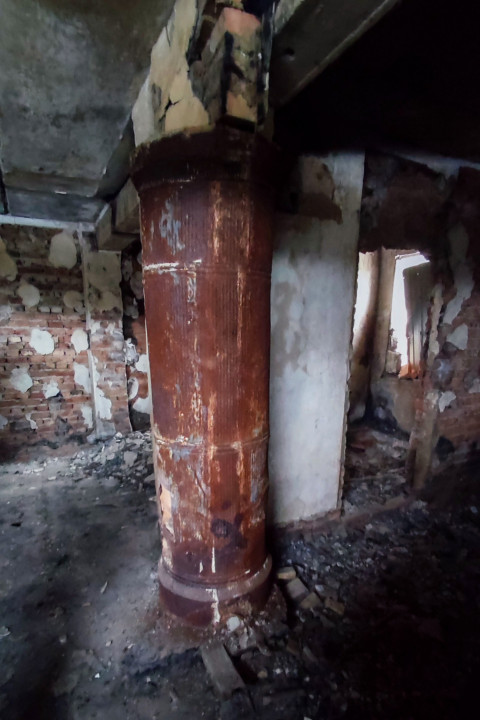 Металлическая отопительная колонна в заброшенном помещении