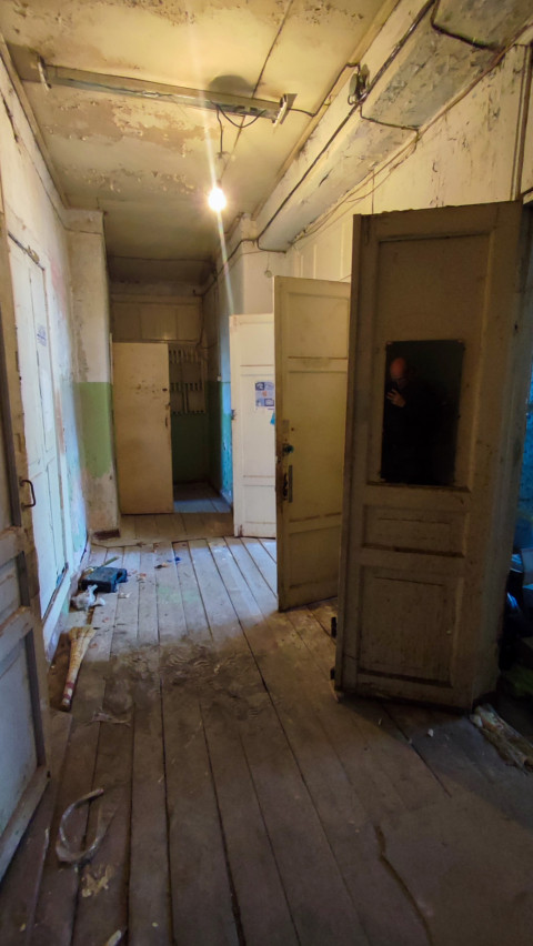 Коридор здания с открытыми дверями и старой проводкой
