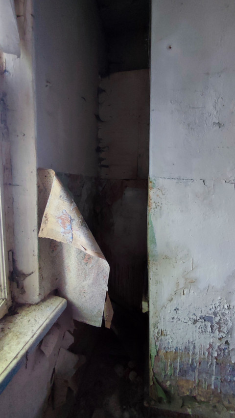 Угол комнаты с отслаивающимися обоями и следами влаги