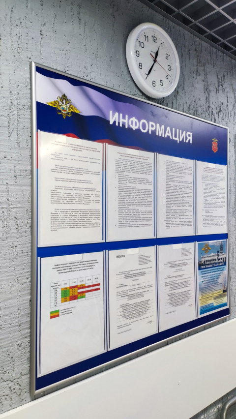 Информационный стенд МВД с настенными часами и перечнем нормативных документов